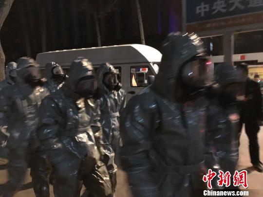 十几名身着防护服的人员头戴面具进入事发地。　胡健 摄